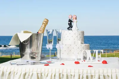 a table with a wedding cake and wine glasses at Polyxenia Isaak Luxury Villas and Apartments in Protaras