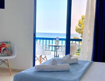 a bedroom with a bed with a view of the ocean at Governors Beach Costas Apts in Governors Beach