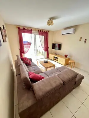 a living room with a large brown couch in a room at Nissi Elena A11 in Ayia Napa
