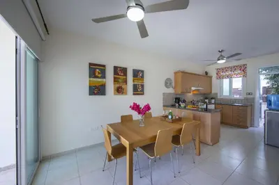 a kitchen and dining room with a wooden table and chairs at Protaras Villa Marilia in Protaras