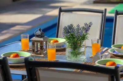 a table with plates of oranges and a glass of orange juice at Protaras Villa Marilia in Protaras