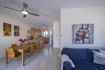 a living room with a blue couch and a table at Protaras Villa Marilia in Protaras