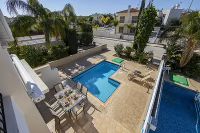 an overhead view of a swimming pool with a table and chairs at Protaras Villa Marilia in Protaras