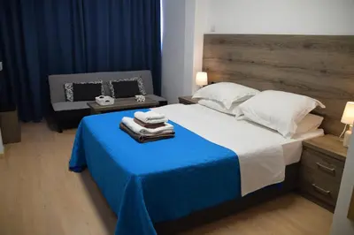 a bedroom with a large bed with a blue blanket at Sea Krystel 603 in Larnaka