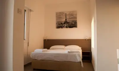 a bedroom with a bed with a picture on the wall at St. George Rent Rooms in Larnaka