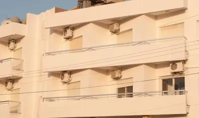 an apartment building with balconies on the side at St. George Rent Rooms in Larnaka