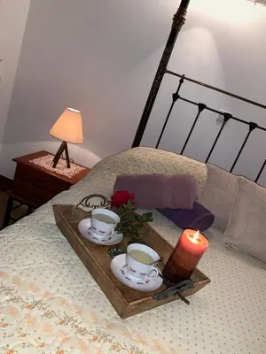a tray with two cups and a candle on a bed at Lofou Traditional House in Lofou