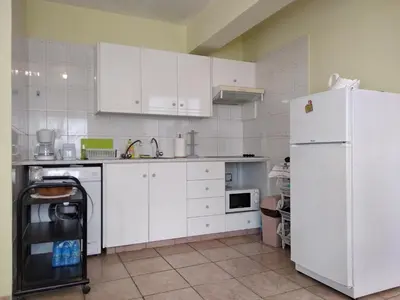 a kitchen with white cabinets and a white refrigerator at Spacious 1 Bedroom Apartment in Kapparis Area in Paralimni