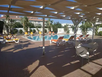 a patio with chairs and a swimming pool at Cosy apartment in a luxury resort in Paralimni