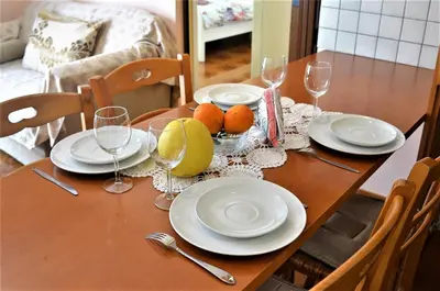 a wooden table with plates and glasses and oranges on it at LIRA in Larnaka