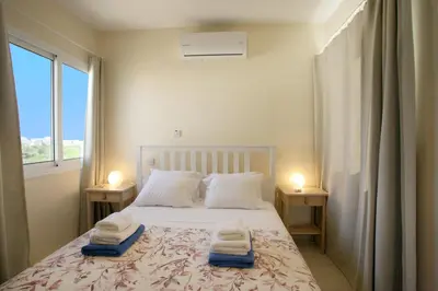a bedroom with a bed with two towels on it at Villa Carmel in Ayia Napa