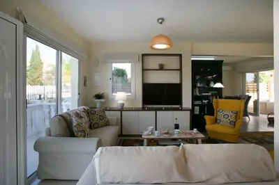 a living room with a couch and a tv at Villa Carmel in Ayia Napa