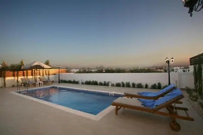 a swimming pool with a lounging chair next to a pool at Villa Carmel in Ayia Napa