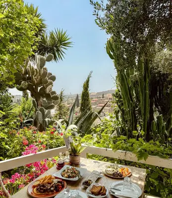 a table with plates of food on top of a garden at Cyprus Villages - Hotel & Restaurant - Central Location - Bed & Breakfast With Access To Pool And Stunning Views in Tochni