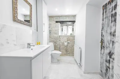 a white bathroom with a sink and a toilet at Cyprus Villages - Hotel & Restaurant - Central Location - Bed & Breakfast With Access To Pool And Stunning Views in Tochni