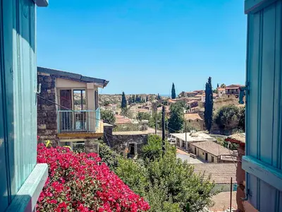 a view of a city from a building with pink flowers at Cyprus Villages - Hotel & Restaurant - Central Location - Bed & Breakfast With Access To Pool And Stunning Views in Tochni