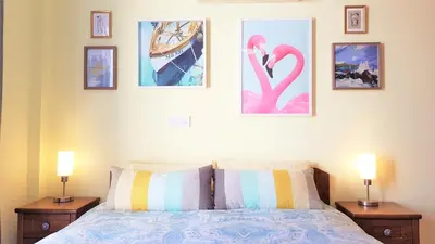 a bedroom with a bed with three pictures on the wall at Palm Paradise Villa in Ayia Napa