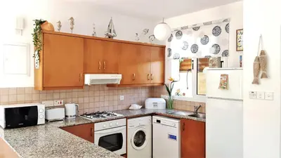 a kitchen with a white refrigerator and a dishwasher at Palm Paradise Villa in Ayia Napa