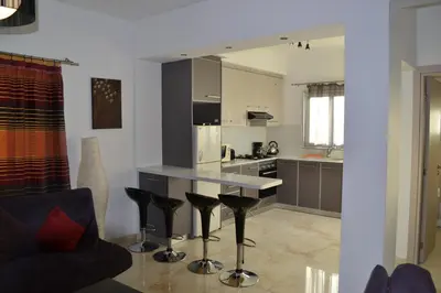 a kitchen with a counter and stools in a room at Makronissos Beach Villas in Ayia Napa
