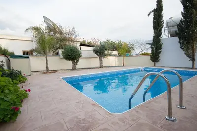 a swimming pool in a yard next to a building at Makronissos Beach Villas in Ayia Napa