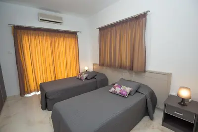a hotel room with two beds and a couch at Makronissos Beach Villas in Ayia Napa