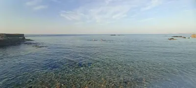a large body of water with people swimming in it at Rustic House in Xylophaghou
