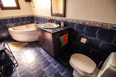 a bathroom with a toilet and a sink and a tub at Rustic House in Xylophaghou