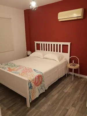 a bedroom with a white bed and a red wall at Yippee!(Perfect Location) in Larnaka