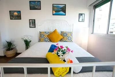 a bedroom with a white bed with flowers on it at Poseidon Boutique Apartment 2 in Limassol