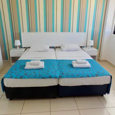 a bedroom with two beds with towels on them at Margarita Napa Apartments in Ayia Napa