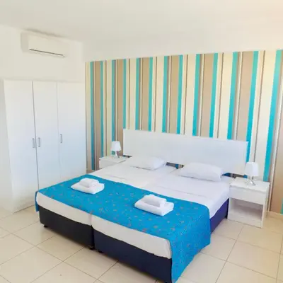 a bedroom with a bed with two towels on it at Margarita Napa Apartments in Ayia Napa