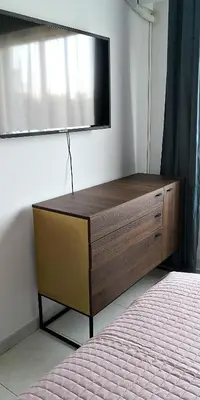a dresser with a flat screen tv on a wall at Cozy Getaway in Nicosia in Yukarı Lakatamya