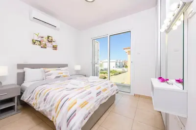 a bedroom with a bed and a large window at Villa Elaine in Paralimni