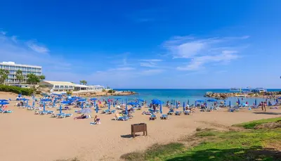 a group of people sitting on a beach at Villa Elaine in Paralimni