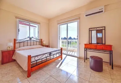 a bedroom with a bed and a dresser and a window at Hadjios Valley in Mazotos