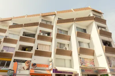 a tall white building with wooden balconies on it at Andriana City Centre Flat in Larnaka