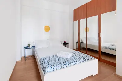 a bedroom with a white bed and a mirror at Welcome! Perfect Location-City Center in Larnaka