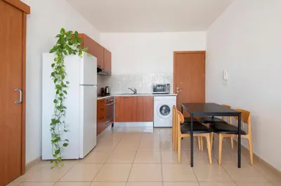 a kitchen with a table and a white refrigerator at Welcome! Perfect Location-City Center in Larnaka