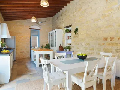 a kitchen and dining room with a white table and chairs at Villa Avgoustis in Pachna