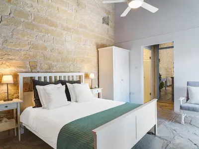 a bedroom with a white bed and a brick wall at Villa Avgoustis in Pachna