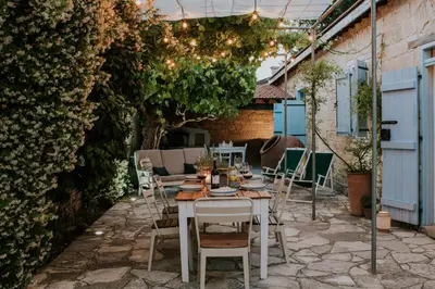 a patio with a table and chairs in a garden at Villa Avgoustis in Pachna