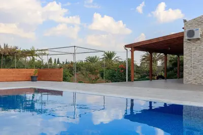 a house with a swimming pool and a pavilion at BerryRose Villa in Pervolia