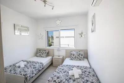 a bedroom with two beds and a window at Villa Anemoni 8 in Protaras