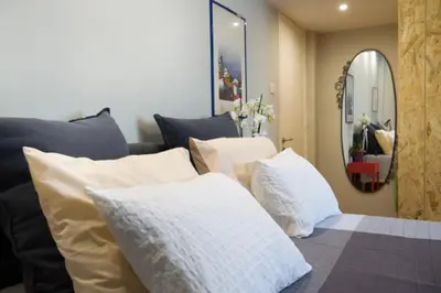 a room with a bed with pillows and a mirror at Strovolos Value Suites in Strovolos