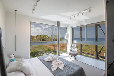 a bedroom with a bed and large windows at Villa Chana in Protaras