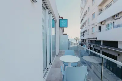 a balcony with tables and chairs in a building at Hai Hotel in Larnaka