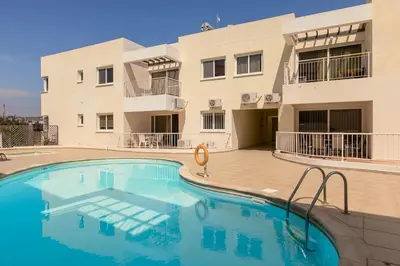 a swimming pool in front of a building at Lovely Bedroom in shared apartment Oroklini in Voroklini