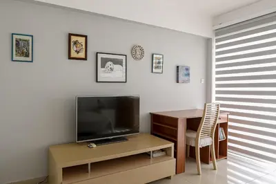 a living room with a table and a television and a table and chair at Lovely Bedroom in shared apartment Oroklini in Voroklini