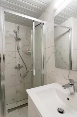 a bathroom with a shower and a white sink at Larnaka Seaview Luxury Suites in Larnaka