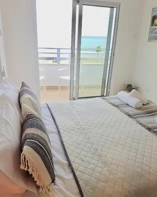 a bedroom with a bed with a view of the ocean at Larnaka Seaview Luxury Suites in Larnaka